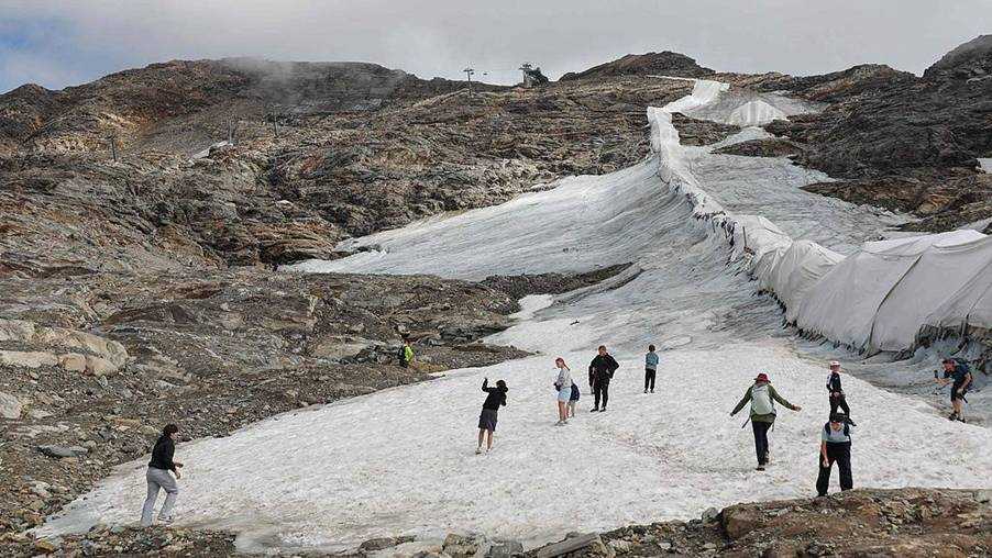 People walk beside protective fleece covering part of the Moelltal Glacier in Carinthia, Austria, on August 19, 2026, as the glacier has shrunk to a narrow strip of snow amid accelerating ice loss across the Alps, where glacier surface area has fallen 39% since 2000. /VCG